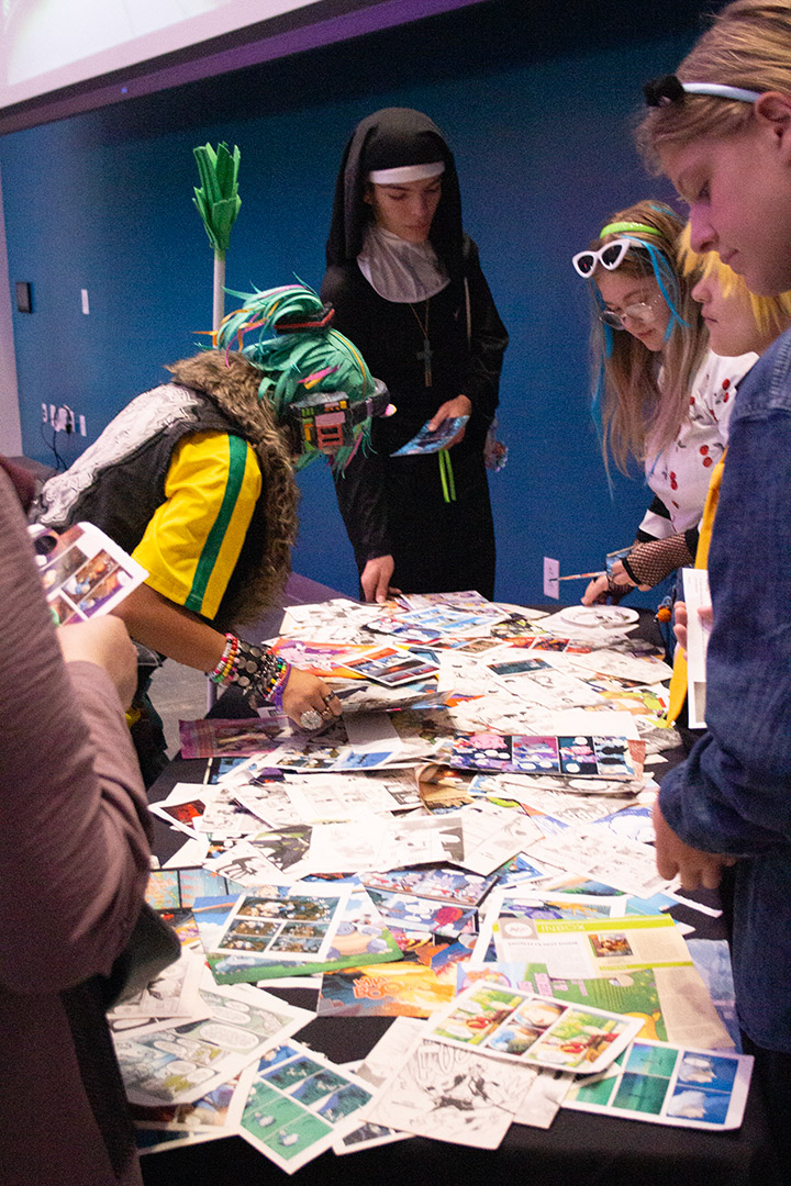 Kids in costume browse mangas on a table